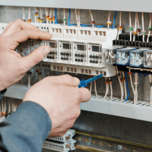 man working on a electric board iwht pliers