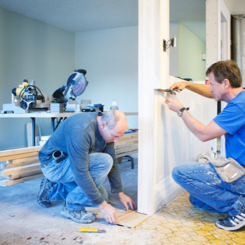 two men doing renovations on a broken house