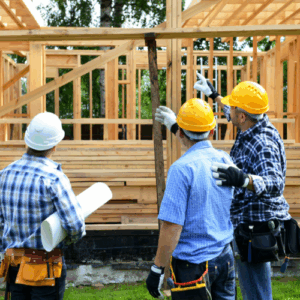 three men discussing work over a house bieng built
